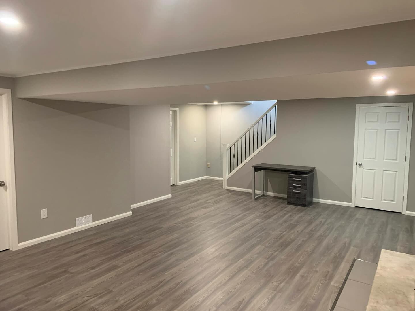 Open finished basement with vinyl plank flooring