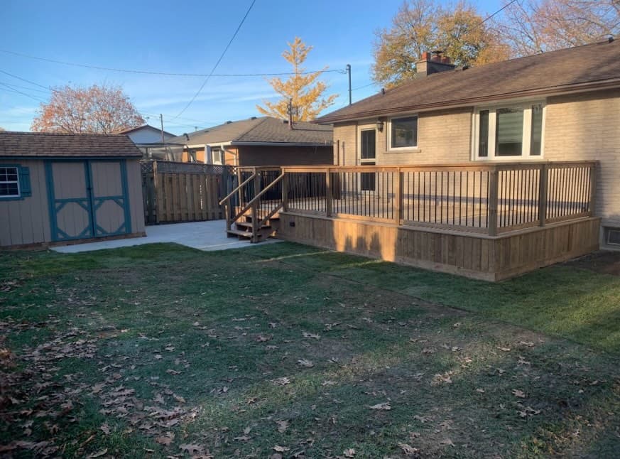 Completed backyard build by NEW BUILD CONSTRUCTION — finished shed, deck, and bungalow at golden hour