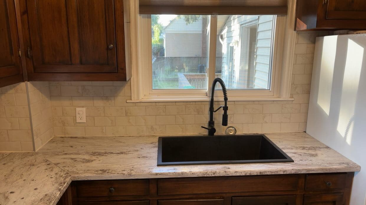 Kitchen with new granite counter, subway backsplash and black sink